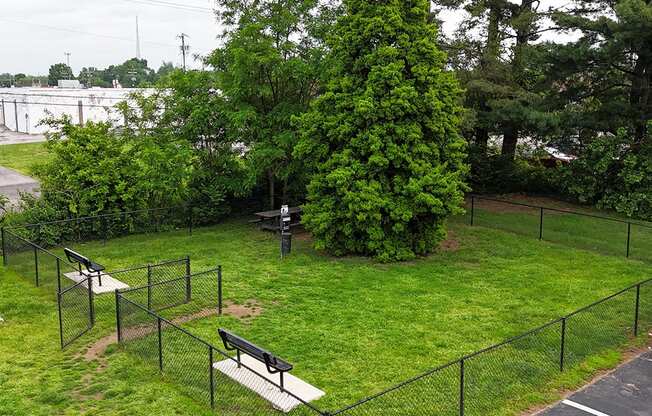A park with a black fence and a bench.