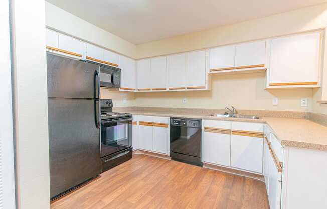 a kitchen with white cabinets and black appliances