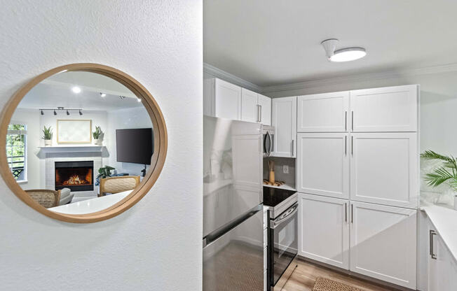 a mirror and a white kitchen with a fireplace