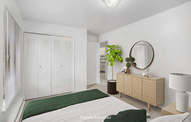 An upgraded bedroom with a green bedspread and a large closet at Wingate Apartments, Michigan