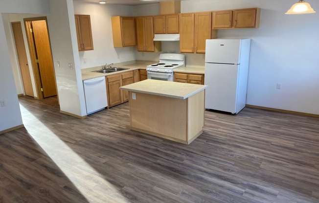 an open kitchen with white appliances and wooden cabinets