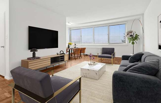 A living room with a grey couch, a wooden entertainment center, and a flat screen TV.