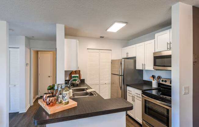 an open kitchen with stainless steel appliances and a large counter top