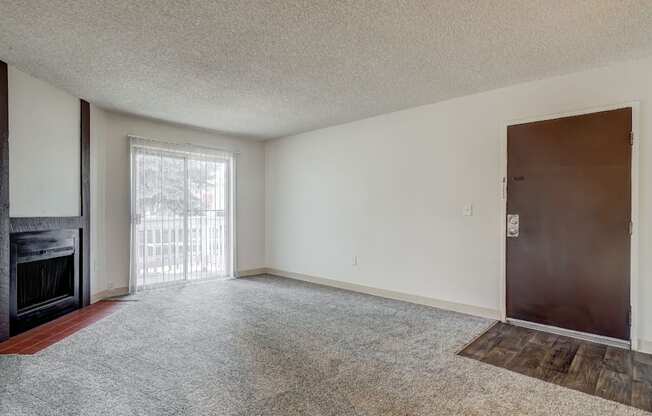 Aurora, CO Apartments – Ivy Crossing – A room with a fireplace and a door.