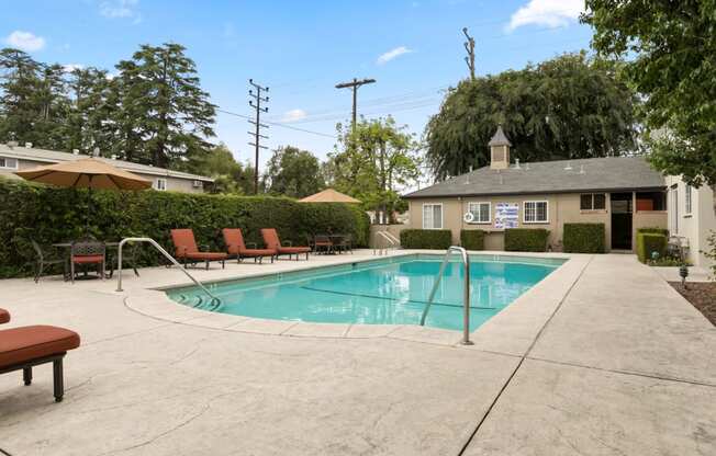 Apartments in Van Nuys, CA - Colonial Manor Swimming Pool with Lounge Chairs and Umbrella Covered Table Seating