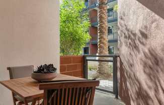 A table with chairs and a bowl of plants on it.