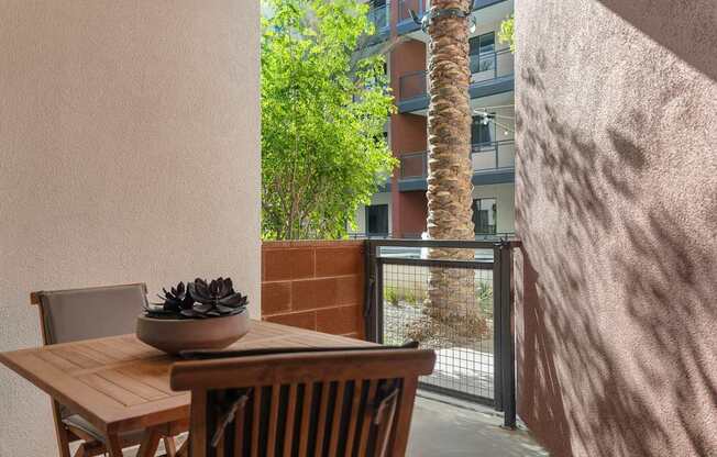 A table with chairs and a bowl of plants on it.
