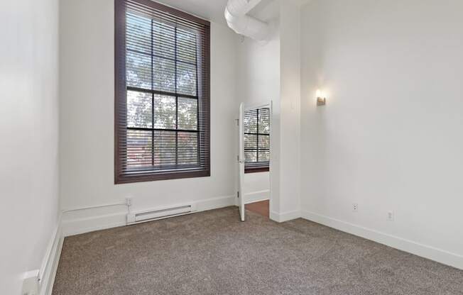 A room with a window and a chair.