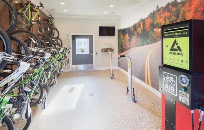 A bike rack with many bikes parked in front of a green recycling bin.