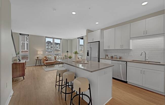 an open kitchen and living room with an island and stools