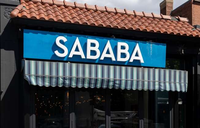 the front of a restaurant with a blue sign that reads sabba