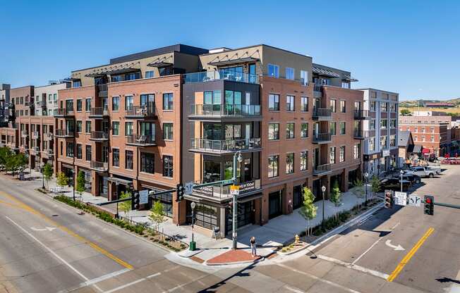 A street view of a city with apartment buildings on the corner.