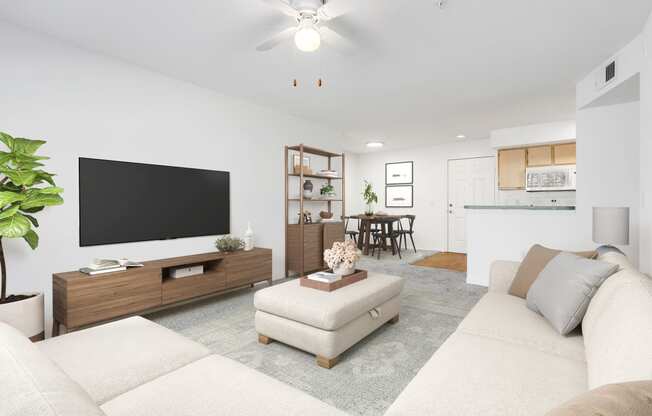 a living room with a white couch and a tv on top of a wooden stand