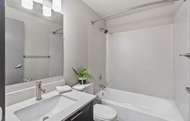 A white bathroom with a sink, toilet, and bathtub.