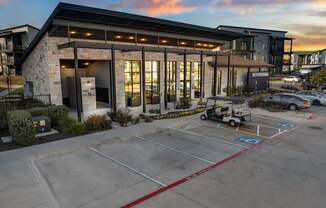 A parking lot in front of a building with a golf cart parked. at Bridge at Tech Crossing, Austin, TX, 78753