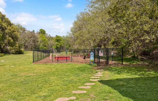 a dog park with a bench and a chain link fence