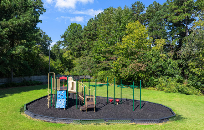 a playground in the middle of a park with trees