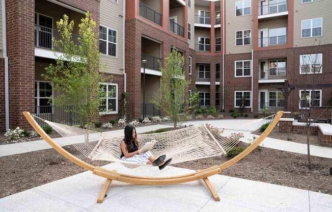 A Women Seating on the Hammock Swing at The Aster Apartments, Cary, NC, 27519