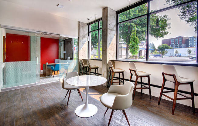 A room with a white table and chairs with a view of the outside. at Ravello Apartments, Redmond, WA, 98052