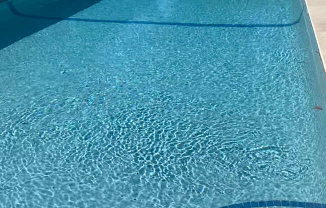 A blue swimming pool with a metal railing.
