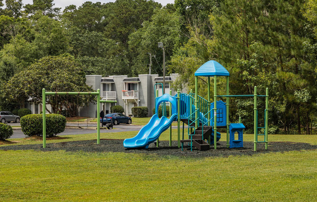 a playground with a slide and monkey bars in front of a building