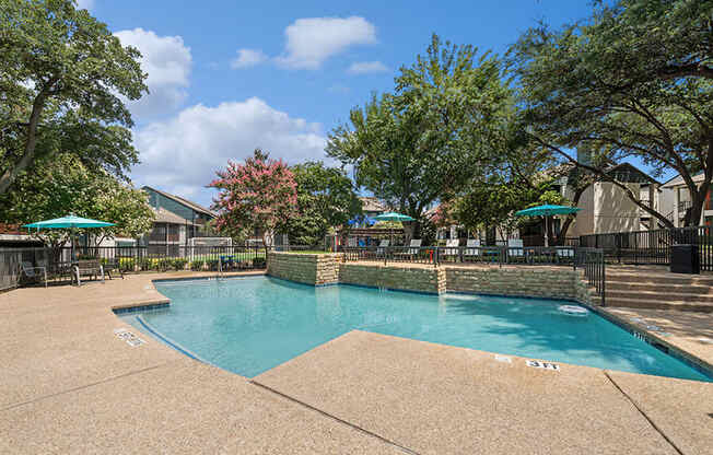 Community Swimming Pool with Pool Furniture at Bridges at Deer Run Apartments in Dallas, TX.