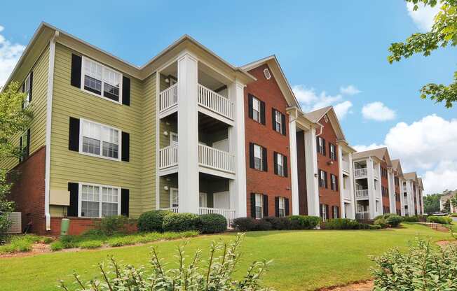 Exterior of apartment with a grass area and flower bed by the building