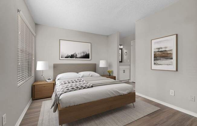 A bedroom with a large bed and two lamps.