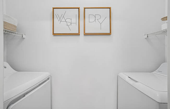 Two dryers in a laundry room with dry and wash signs on the wall.