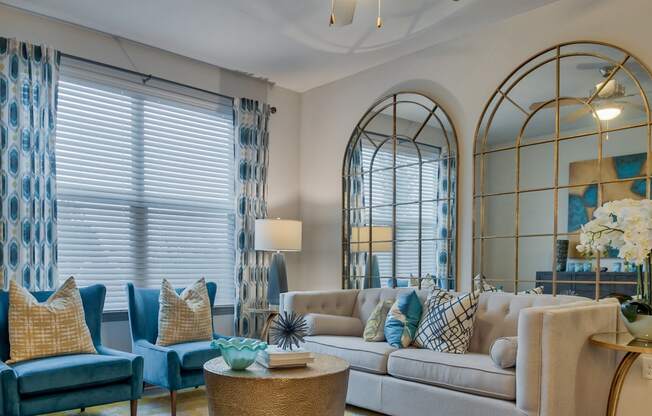 Living room with couch and windows at Parc at Bentonville Apartments in Bentonville, AR