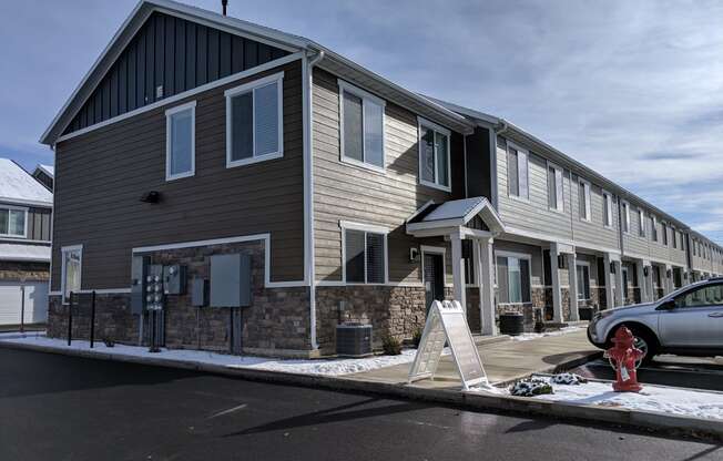 a building with a sign in front of it and a car parked