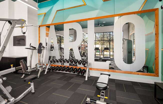 a gym with weights and cardio machines and a large sign with the word rehab on