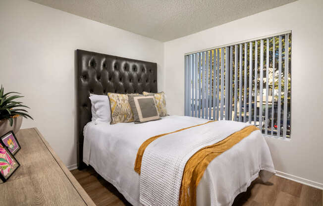 A bedroom with a white bed and a brown headboard.