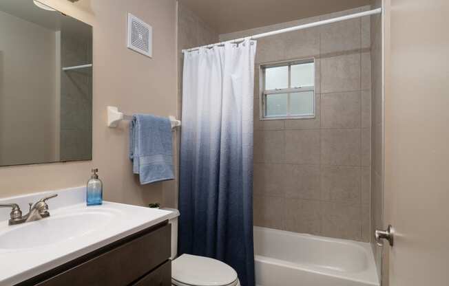 a bathroom with a shower and a sink and a toilet