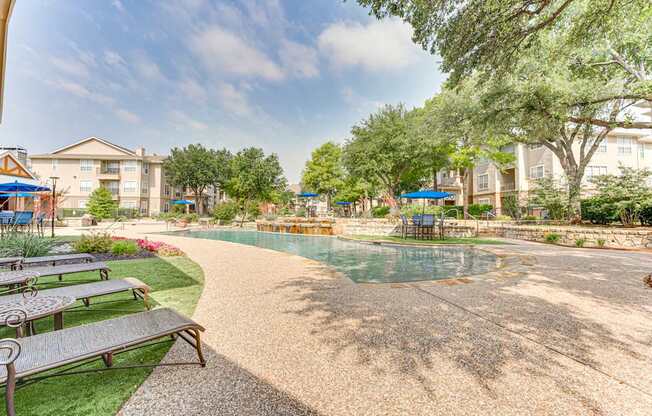 A pool area with a concrete floor and a bench.