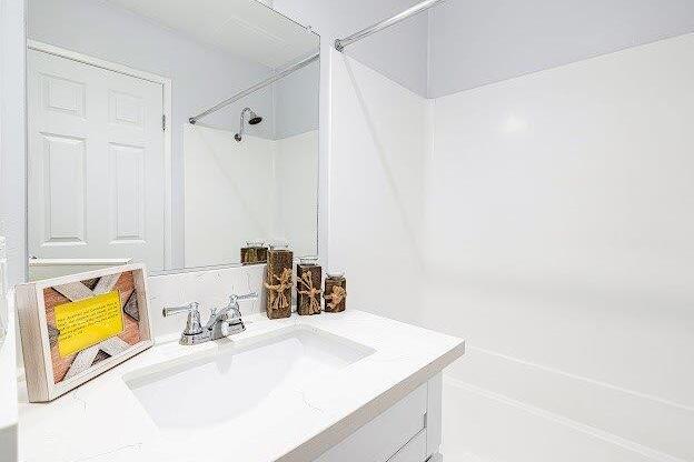A white bathroom with a sink and a mirror.