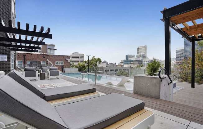 A rooftop patio with a hot tub and a view of the city.