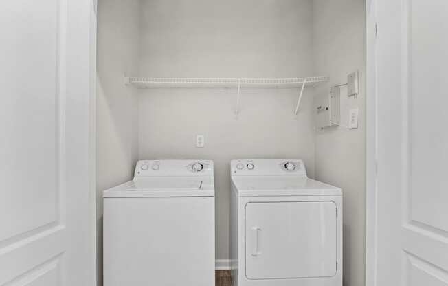 A white laundry room with a washer and dryer.