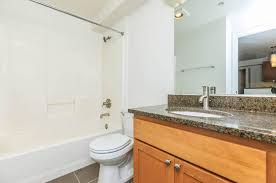 A bathroom with a toilet, sink, and mirror.
