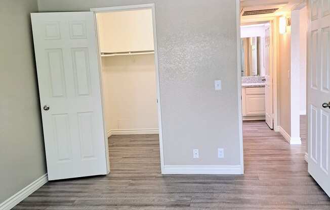 A room with a white door and a wooden floor.