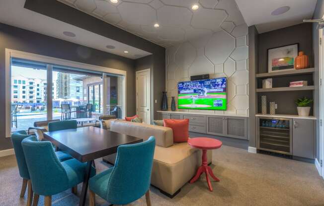 a resident clubhouse with a table and chairs and a flat screen tv