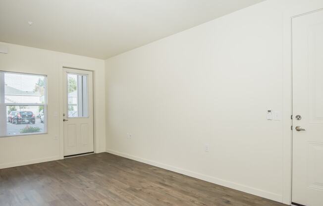 a living room with white walls and a wood floor