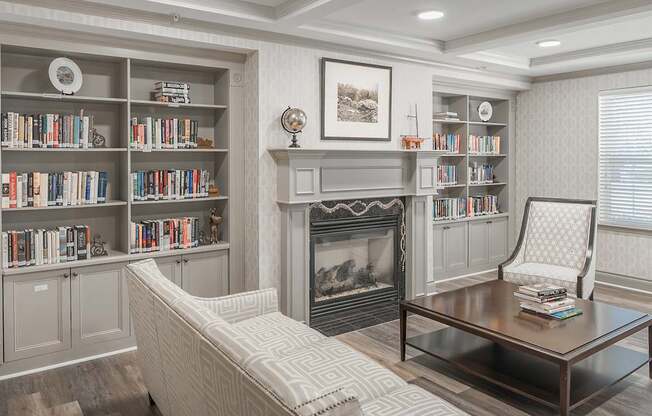 A living room with a fireplace, bookshelves, and a chair.