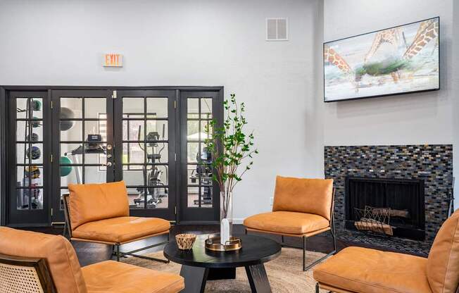 A living room with a fireplace and a painting of giraffes on the wall.