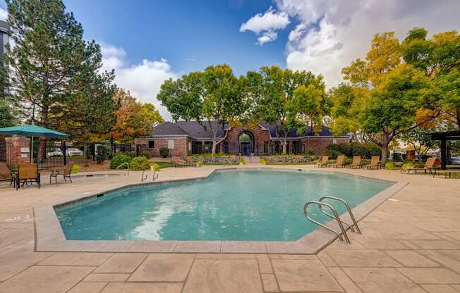 a swimming pool with trees and a house in the background