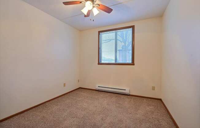 an empty room with a ceiling fan and a window at France, Fargo, ND