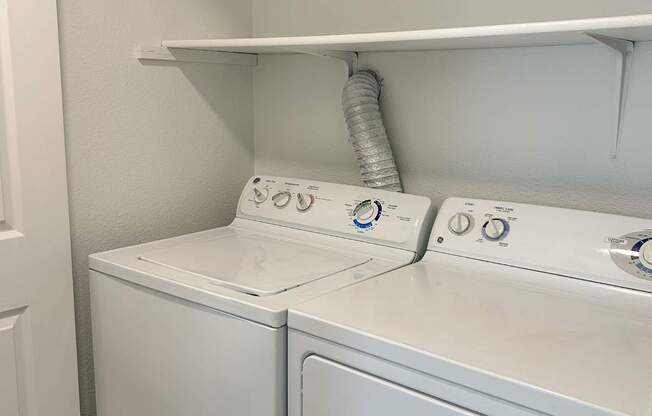 A white washing machine and dryer in a small laundry room.