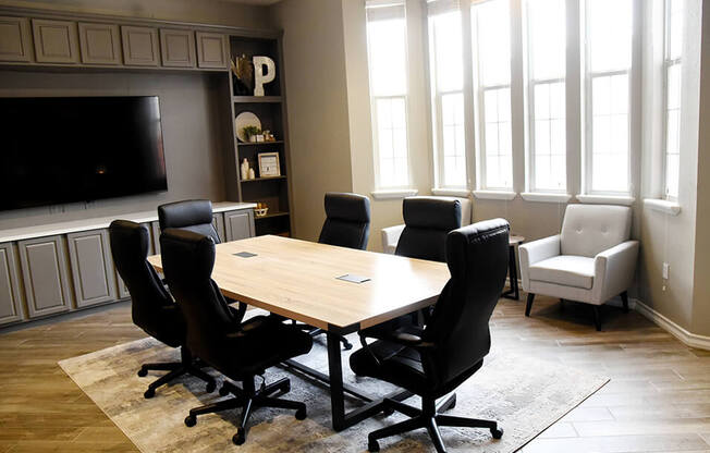 a conference room with a table and chairs and a tv