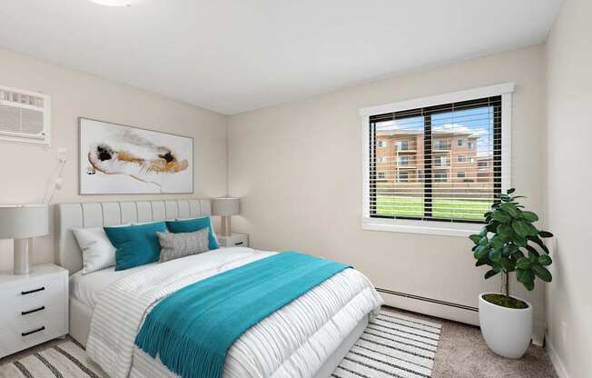 A bedroom with a large bed and a potted plant.
