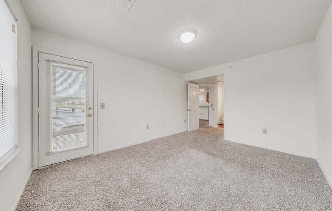 A room with a carpeted floor and a ceiling fan.